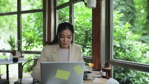 Young woman using laptop in coffee shop.
