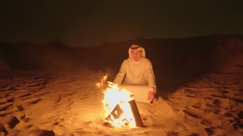 Arabian Desert Night Scene with Man Sitting Beside Campfire