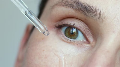 Eye Receiving Drops from Glass Dropper in Close-Up