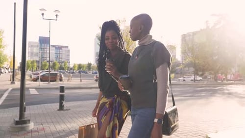 Women Friends With Coffee Walking And Talking In Sunny City Slow Motion