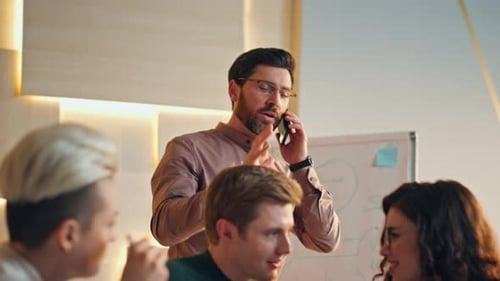 Confident team leader talking phone at office corporate meeting close up