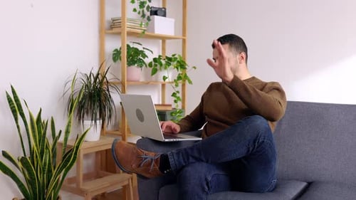 Young Adult Video Chatting on Laptop at Home