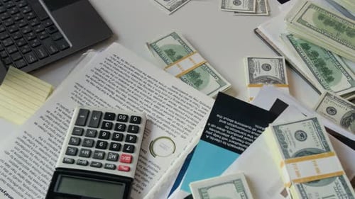 Office Desk with Stacks of Hundred-Dollar Bills, Financial Documents and Laptop