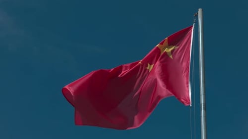 Chinese Flag Waving Against a Clear Blue Sky