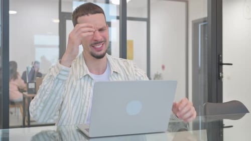 Tired Man Working on Laptop in Office
