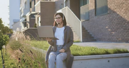 Woman Holding Laptop Engaged in a Video Conference