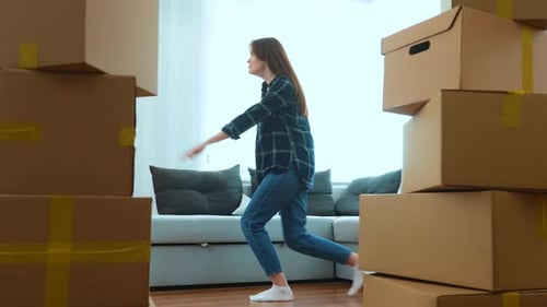 Playful Couple Dancing Amongst Moving Boxes at Home