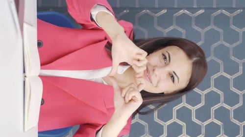 Smiling Young Woman Gesturing in Office, Vertical Format