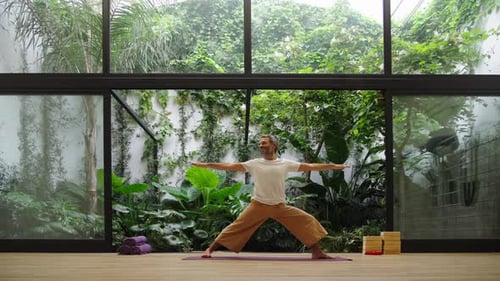 Man Doing Yoga Pose on a Mat Indoors