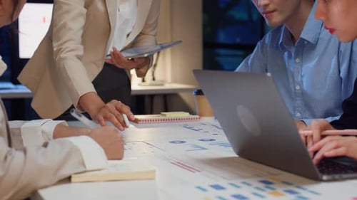 Closeup Asia businesspeople meeting brainstorming some new ideas about project at office night.