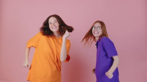 Two Friends Dancing Joyfully in Colorful Studio