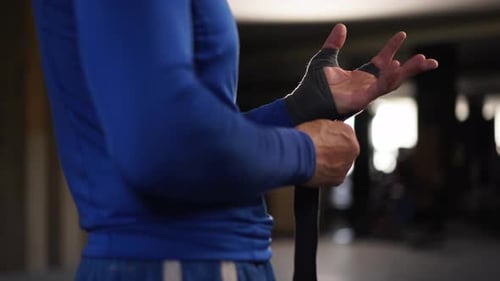 Athletic Man Wrapping Hands with Boxing Bandages at Gym Male Fighter Wrapping His Hands with Black