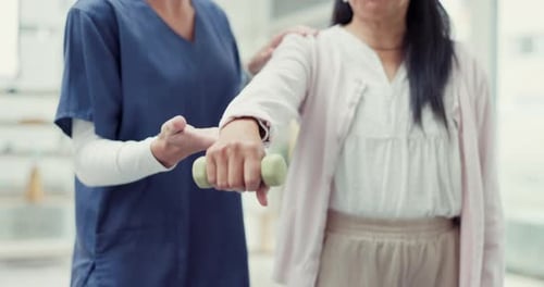 Physical Therapist Assisting Senior Woman with Arm Exercise
