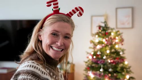 Smiling Woman with Christmas Tree Enjoying Cozy Drink
