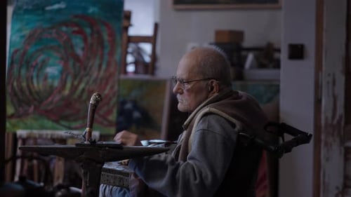 Senior Elderly Master Jeweler in Wheelchair Works in a Workshop