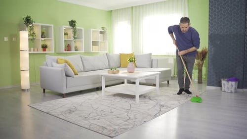 Homme mûr faisant le ménage à la maison et nettoyant avec une serpillière.