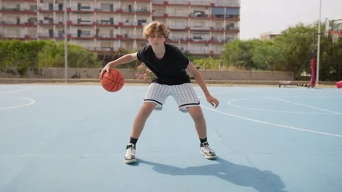 Young Italian Athlete Dribbles Under His Legs On The Basketball Court