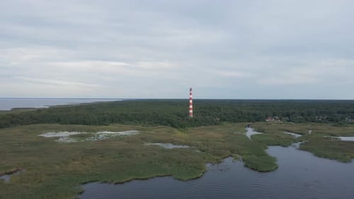 Old lighthouse, around green forest, aerial shot. Remote place of Ladoga lake, Republic of Karelia.