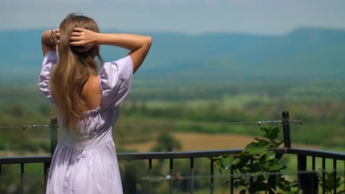 Woman Enjoys Sweeping Rural Vista on Sunny Day