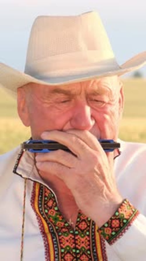 Senior Man Plays Harmonica in Rural Setting