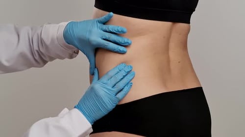 Healthcare Professional Examining Patient is Flank Area