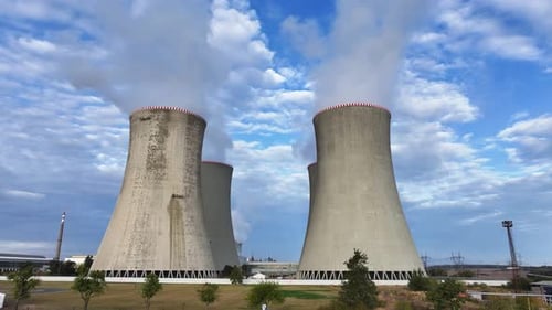 Aerial approach toward nuclear power plant cooling towers while emit vapor
