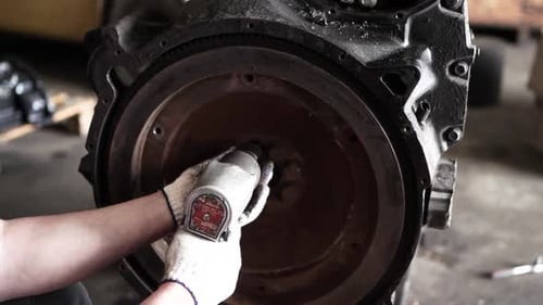 Mechanic Repairing Engine with Power Tool in Workshop