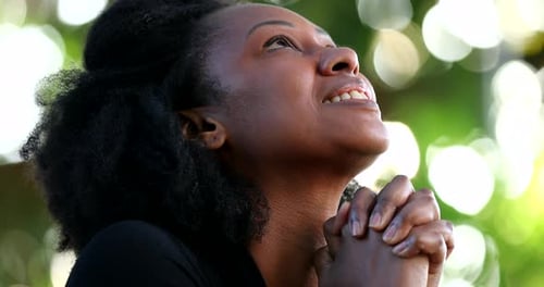 Woman Praying and Smiling with Hope Outdoors
