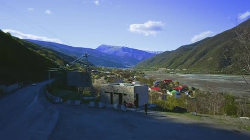 Aragvi River overview aerial view, old town on a river, mountains in a distance