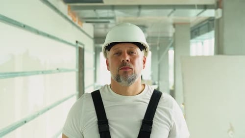 Portrait of a Confident 40s Builder in Safety Helmet on the Construction Site