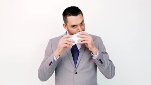 Happy hispanic businessman smelling dollar money packets in office triumph