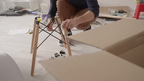 Low Angle View of Man Assembling Chair in New Apartment
