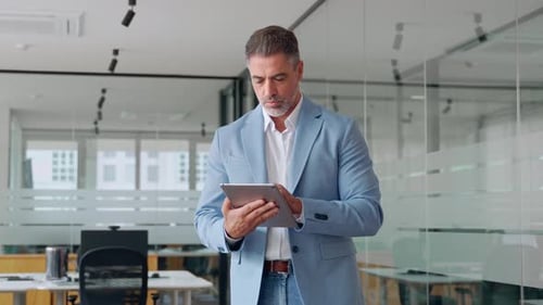 Middle Aged Business Man Executive Using Digital Tablet Standing in Office