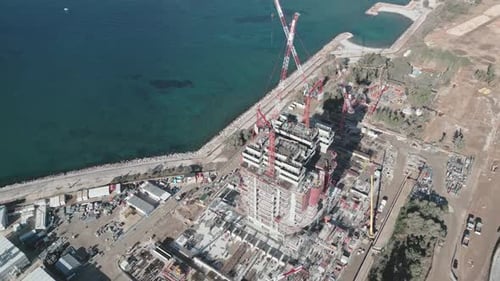 Aerial footage of skyscraper construction site with cranes in Athens, Elliniko on seaside