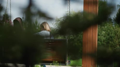 Woman Takes Guitar From Case On Swing Bench