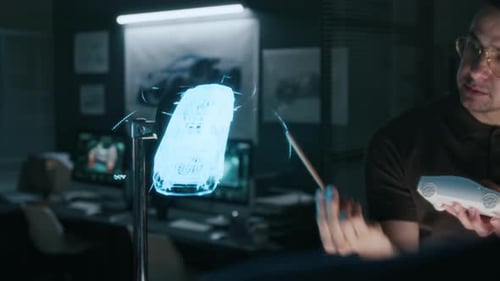 Un jeune ingénieur présente une projection 3D d'un concept-car lors d'une réunion d'équipe