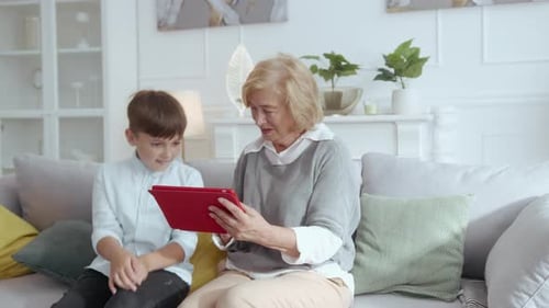 Grandmother and Grandson Using Tablet Together at Home