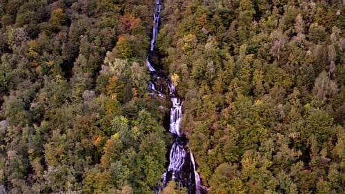 drone panorama of a valley in the alps mountains with a waterfall