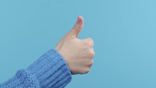 Hand Giving a Thumbs Up on Blue Background