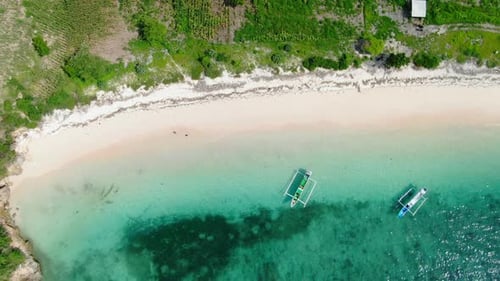 Bird’s eye view ascending shot, scenic view of beach in Lombok, Indonesia, pump boat parked on the s