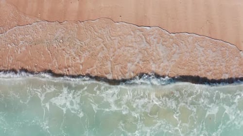 Tropical beach with turquoise ocean water and foaming waves, aerial view. Top view of beach and wave