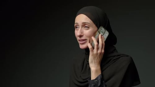 Woman in Black Muslim Headscarf Talking on Mobile Phone