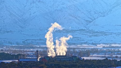 Winter Industrial Scene with Sugar Factory and Snow-Covered Mountains