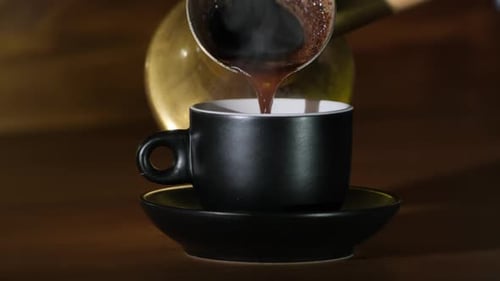 Pouring Fresh Coffee into Black Cup