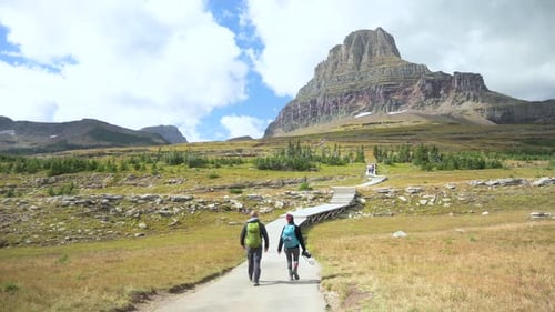 Hikers walking towards Clements Mountain on the Hidden Lake Trail in Glacier National Park, static