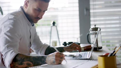 Young Architect with Laptop Indoors in Home Office Working