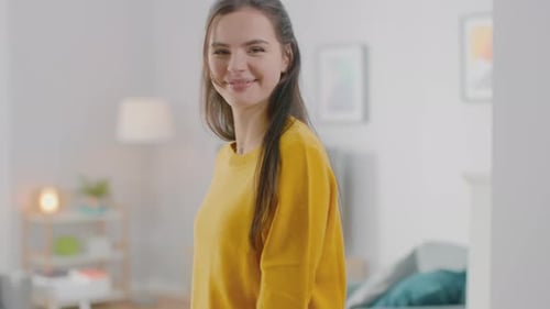 Smiling Young Woman in Yellow Sweater Indoors