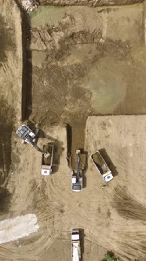 Vídeo vertical: máquinas pesadas y trabajadores colaboran para preparar la base