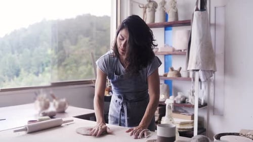 Business owner, Artist work at pottery workshop ceramic studio, Woman kneading clay