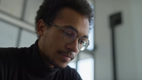 Young Adult Man With Glasses Looking Down Close Up